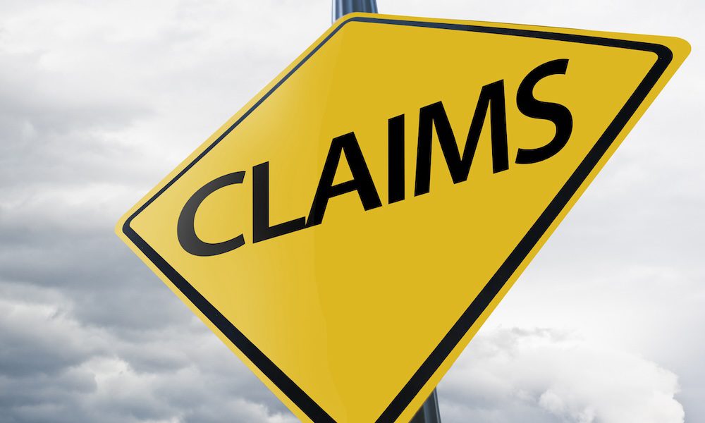 Claims warning road sign against sky
