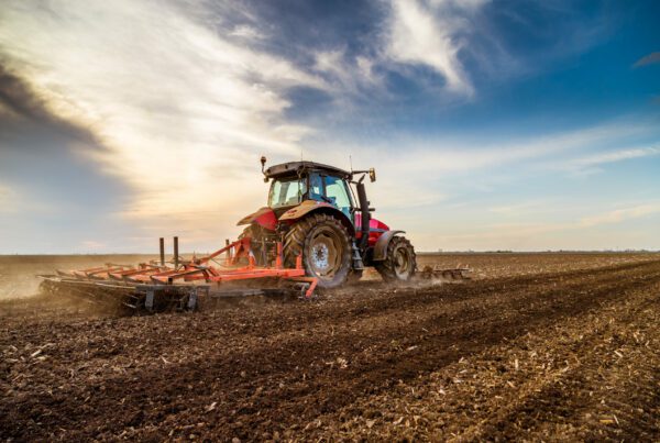 Blog - Tractor cultivating field at spring