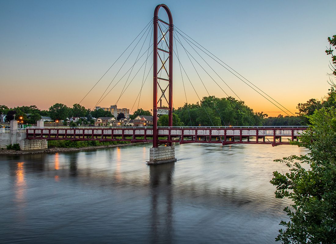 Mishawaka, IN - View of a Red Bridge Across the Water Leading into the City of Mishawaka Indiana During the Evening
