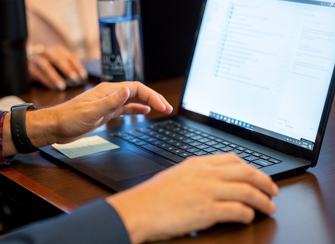 Resources - Closeup View of a Business Man's Hands Using a Laptop During a Business Meeting in the Synergy Insurance Office