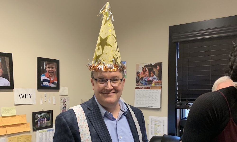 Insurance Erkels: “Did I Do That?” - Agency Team Member Dressed In Party Hat Smiling At Camera